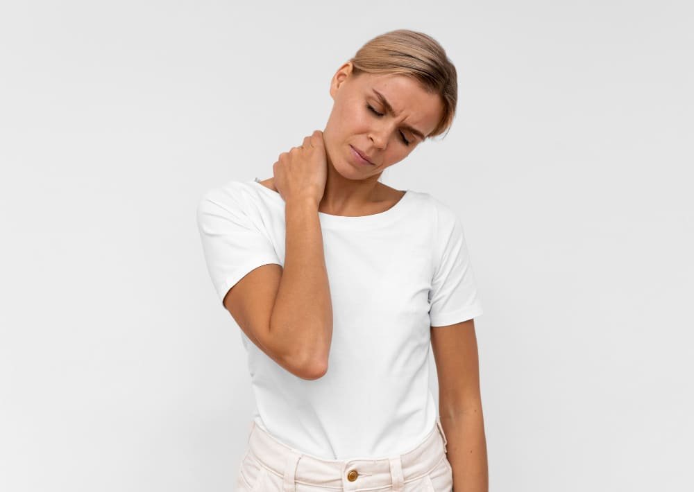 mujer con dolor de cuello tocandose la parte posterior