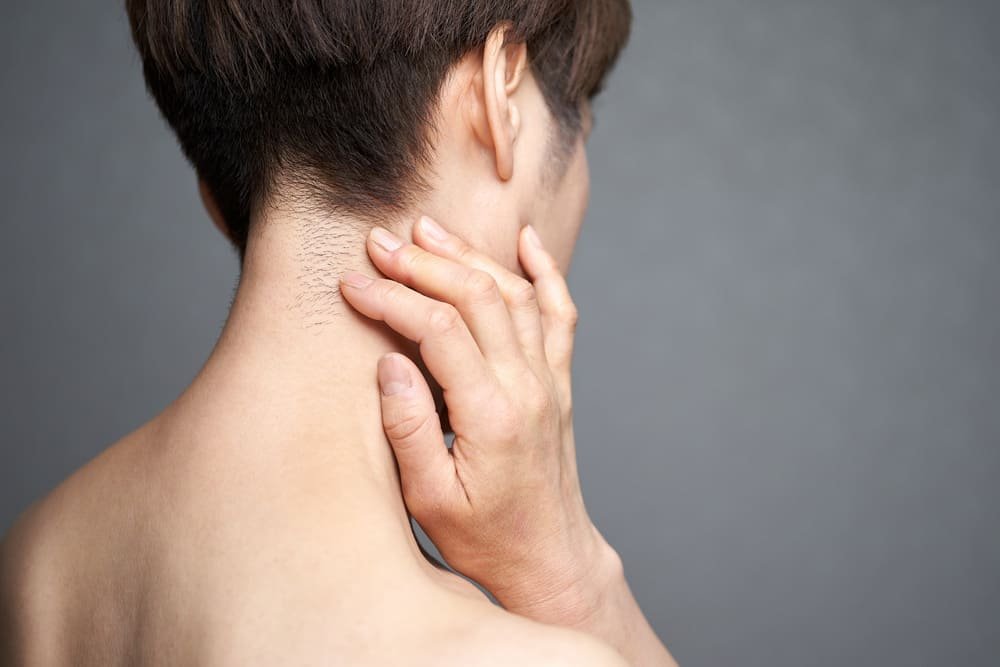 mujer japonesa de mediana edad sujetando zona dolorida