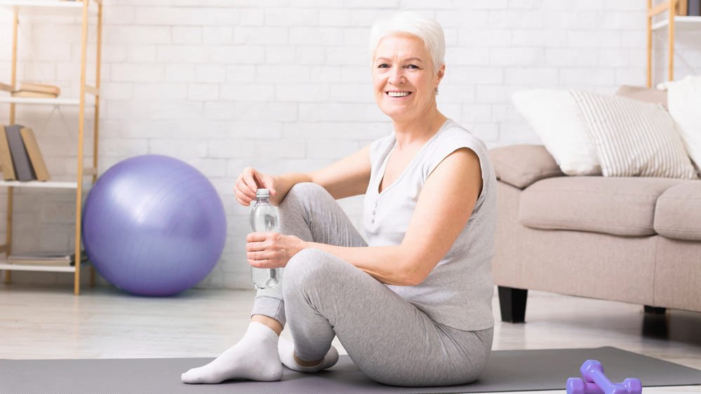 mujer senior descansando sobre colchoneta de ejercicio despues de fitness